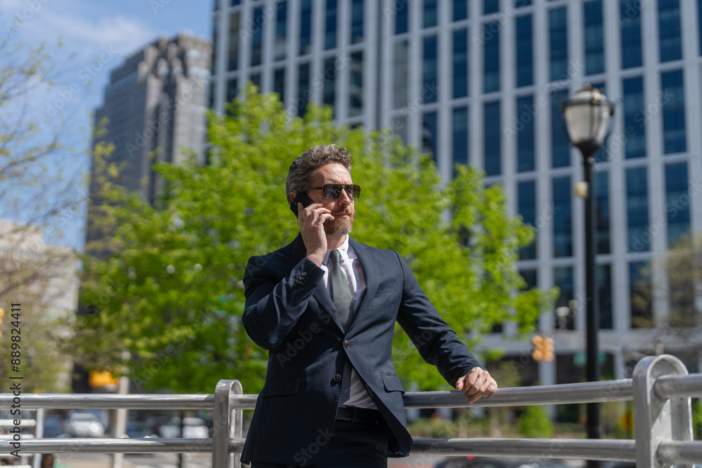 Businessman using phone. Man phone conversation in suit. Middle aged Hispanic businessman with phone. Business communication. Business man having phone call outdoor. Communication strategy Businessman using phone. Man phone conversation in suit. Middle aged Hispanic businessman with phone. Business communication. Business man having phone call outdoor. Communication strategy