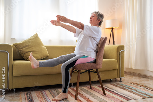 Senior caucasian woman doing yoga at home on chair