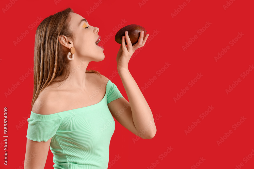 Beautiful young woman with sweet mango fruit on red background Beautiful young woman with sweet mango fruit on red background
