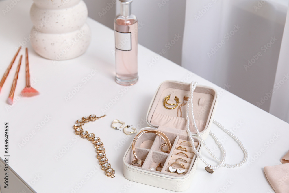 Box with stylish different jewelry on dresser, closeup Box with stylish different jewelry on dresser, closeup