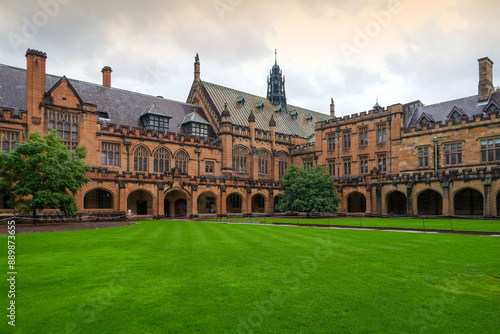 Sydney, New South Wales, Australia - April 19, 2023: Summer view of green lawn and University of Sydney with entrance door and red wall against dark cloud in the sky
 photo