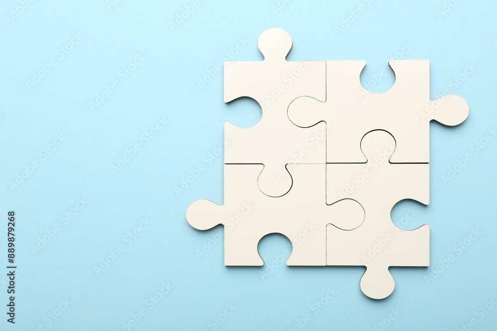 White puzzle pieces on light blue background, top view. Space for text White puzzle pieces on light blue background, top view. Space for text