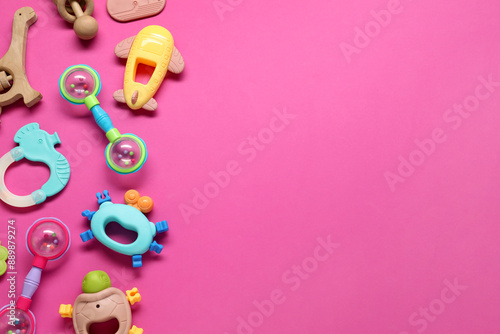 Different baby rattles on pink background, flat lay. Space for text