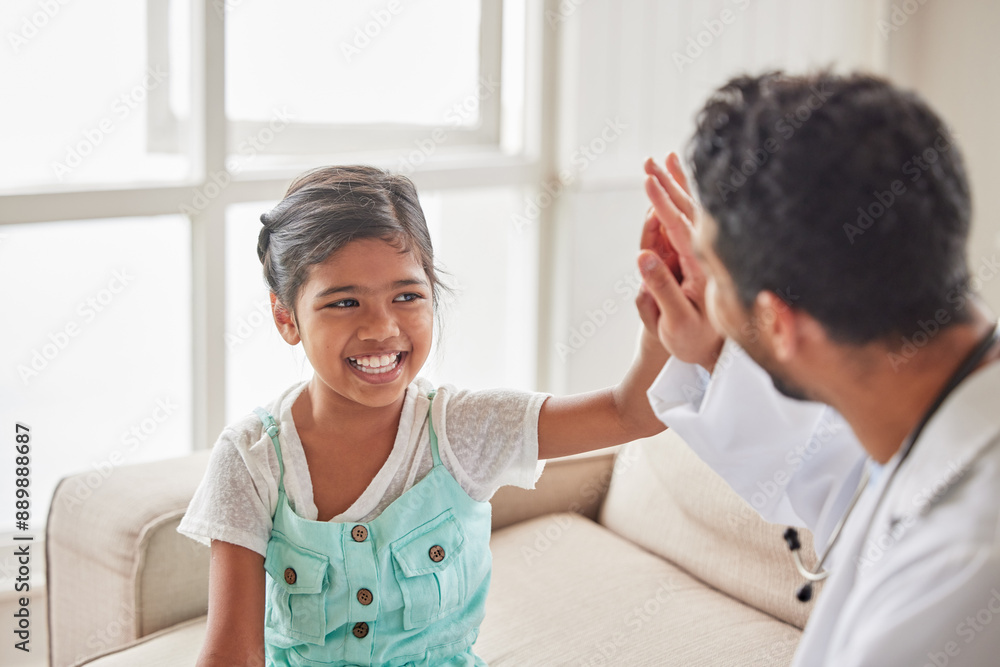 Doctor, girl and high five in home, happy and excited with support for results with wellness on sofa. Pediatrician, man and child at family house, cheers and celebration for good news in Indonesia Doctor, girl and high five in home, happy and excited with support for results with wellness on sofa. Pediatrician, man and child at family house, cheers and celebration for good news in Indonesia