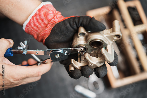 Mechanic remove a seized brake caliper piston with motorcycle caliper piston removal tool in garage, maintenance and repair concept