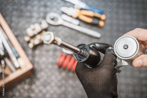 Obraz na płótnie Mechanic holding motorcycle rear shock absorber old and leak , Replace shock absorbers seals in garage, maintenance and repair concept. w salonie