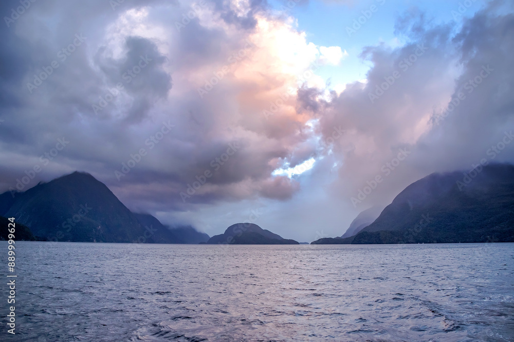 Seascape, dawn and early morning over the water in a fjord in cloudy weather, Doubtful Sound Fiord, New Zealand Seascape, dawn and early morning over the water in a fjord in cloudy weather, Doubtful Sound Fiord, New Zealand