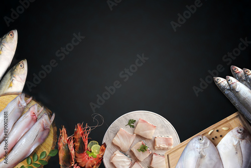 Assorted fish over black background. Mackerel, bangda, Bombay duck or bombil, Prawns, and silver pomfret banner. fresh fish website banner with copy space. photo