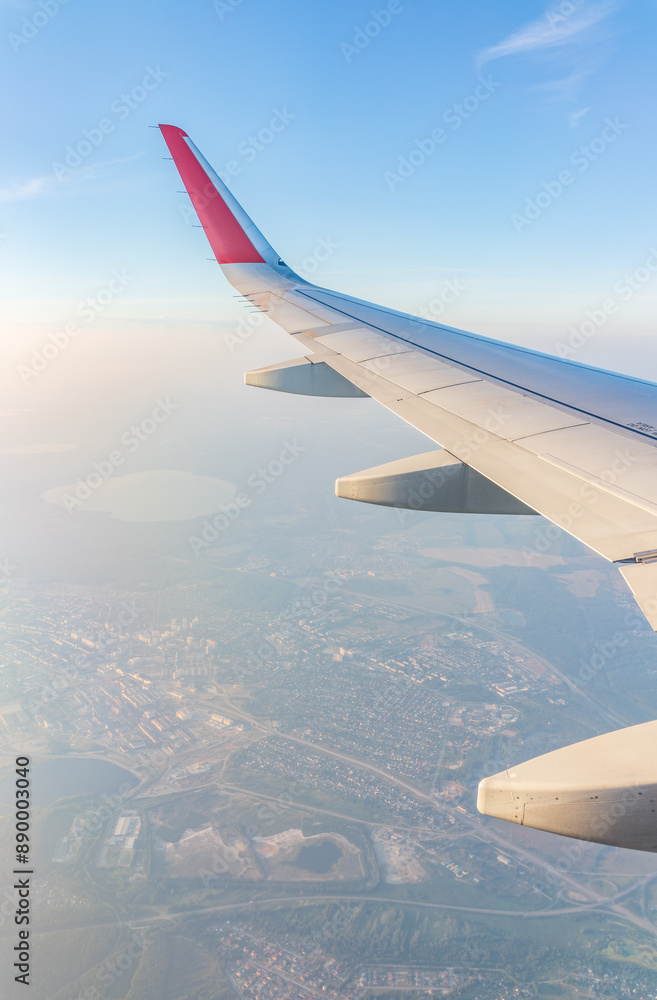 Fototapeta premium View from the airplane window at a beautiful cloudy sky and the airplane wing