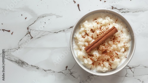 Arroz con leche Rice pudding with cinnamon in bowl on white marble Top view Copy space photo