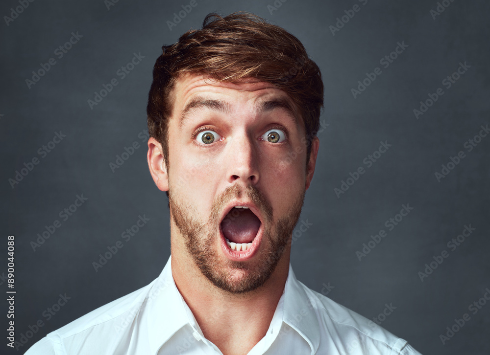 Portrait, surprise and man in studio, wow or journalist with shock for announcement of award for story. Grey background, mockup and face of excited reporter, rumor or good news for person or reaction Portrait, surprise and man in studio, wow or journalist with shock for announcement of award for story. Grey background, mockup and face of excited reporter, rumor or good news for person or reaction