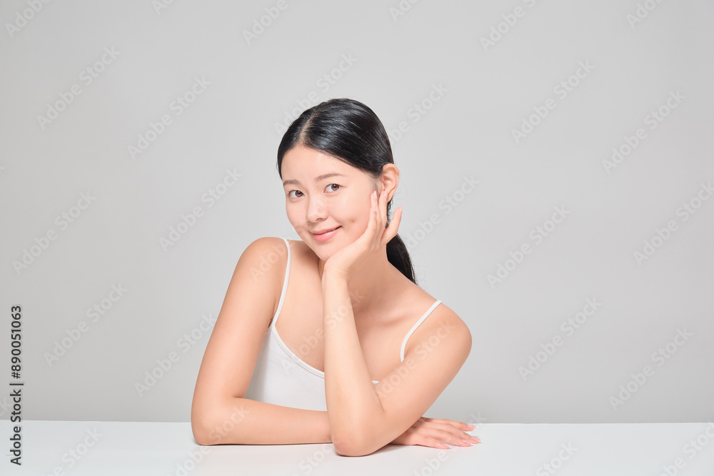 Asian female cosmetics model smiling confidently. A pose where the chin is supported. Asian female cosmetics model smiling confidently. A pose where the chin is supported.