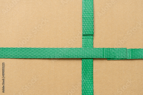 close up of green packaging plastic belt from the cardboard box that shows the connection point