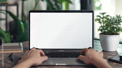 a mockup of a laptop with blank screen with hands typing on the keyboard, office background