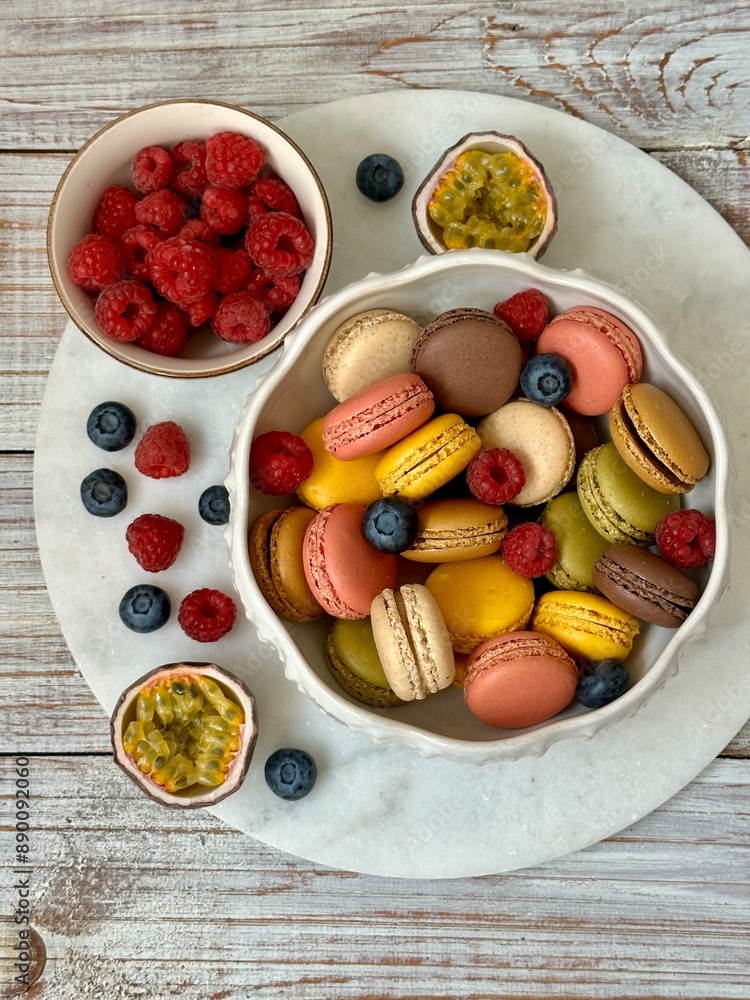 Macarons in different colors and tastes in the white plate and raspberries, blueberries and passion fruit on the marble plate on the wooden background
Macarons in different colors and tastes in the white plate and raspberries, blueberries and passion fruit on the marble plate on the wooden background