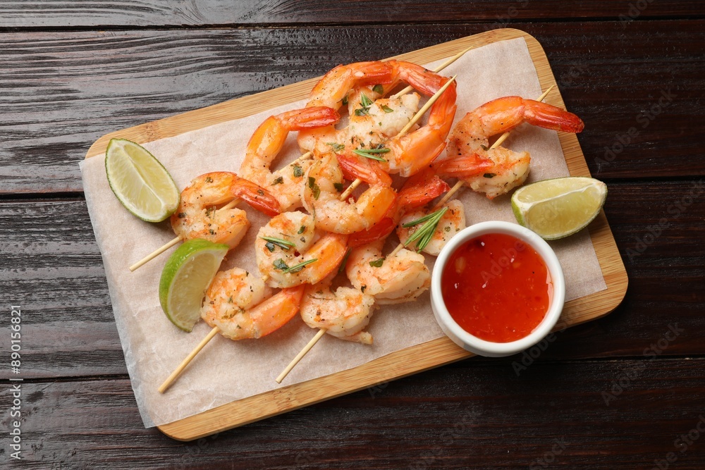Skewers with delicious grilled shrimps served on wooden table, top view Skewers with delicious grilled shrimps served on wooden table, top view
