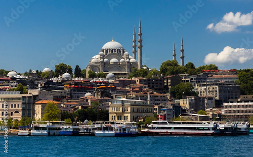 Photography Suleymaniye Mosque with minarets sits on a hill overlooking the water of Golden Horn bay
