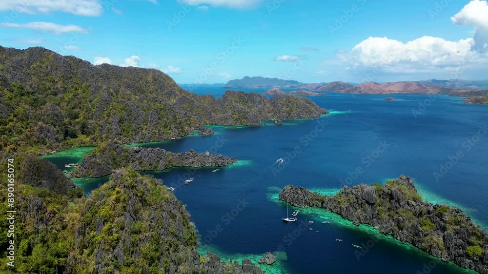 Experience a serene descent over the vibrant Twin Lagoon on Coron Island, Philippines. This drone footage gently lowers towards the turquoise and emerald waters nestled among jagged limestone cliffs. Experience a serene descent over the vibrant Twin Lagoon on Coron Island, Philippines. This drone footage gently lowers towards the turquoise and emerald waters nestled among jagged limestone cliffs.