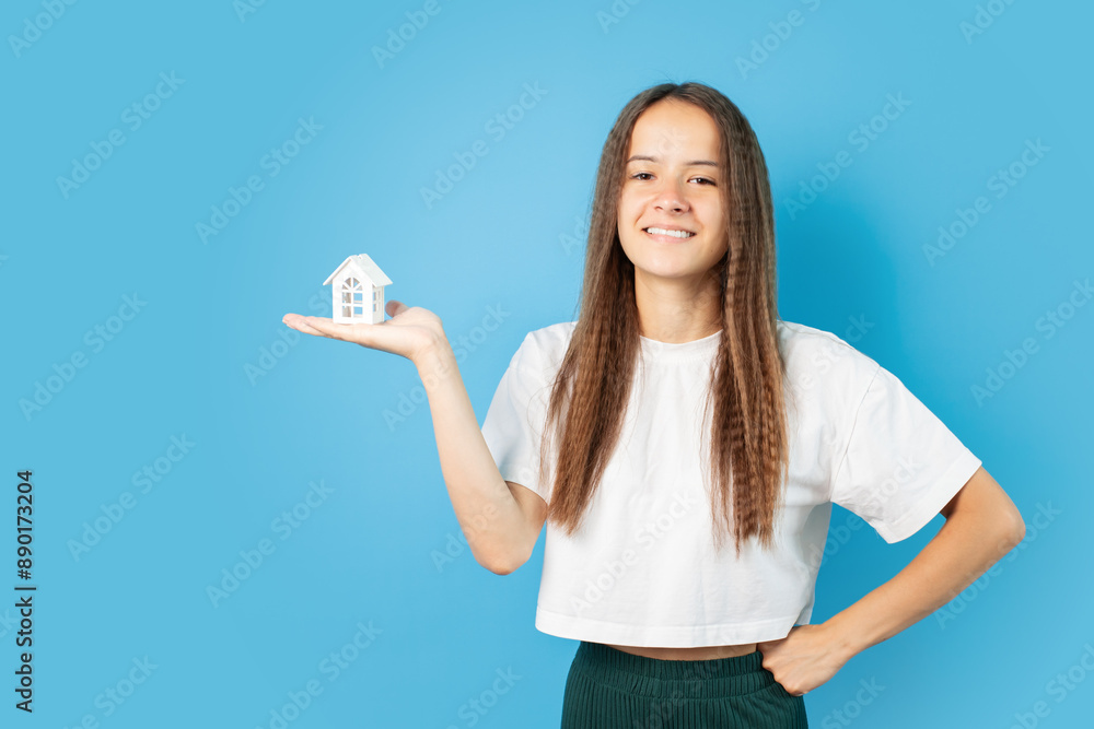 Obraz premium Mortgage sell, teenage girl with house, curly-haired teenager with new property, teen's first real estate purchase