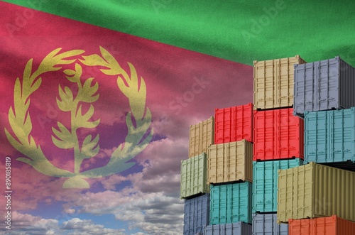 Eritrea flag and big stack of shipping cargo containers in docks with sky background close up photo