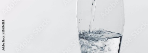 pouring clear water into a transparent water glass isolated on white background banner, abstract closeup concept of a refreshing beverage with copy space