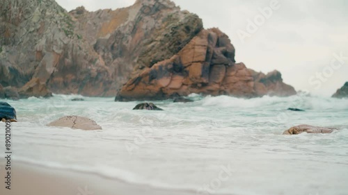 Ocean waves crashing on Rocks. Cliffs in the background.
