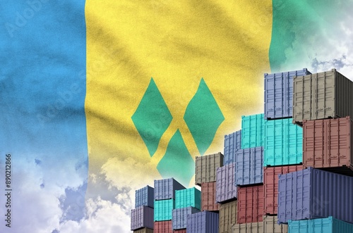 Saint Vincent and the Grenadines flag and big stack of shipping cargo containers in docks with sky background close up photo