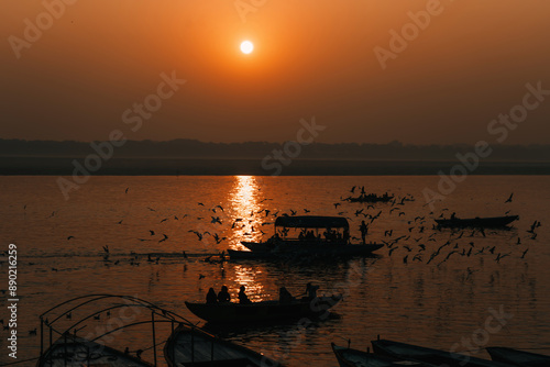 Photography Boats and birds during dawn on sacred river Ganges in Varanasi, India