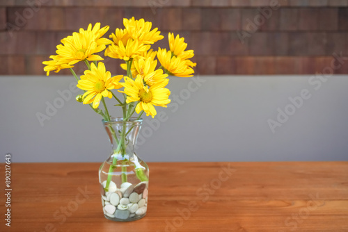 Wallpaper Mural Real a bunch of yellow daisy flower bouquet in transparent glass vase on wooden table. Modern interior design of modern office work room or workplace with plant. Torontodigital.ca