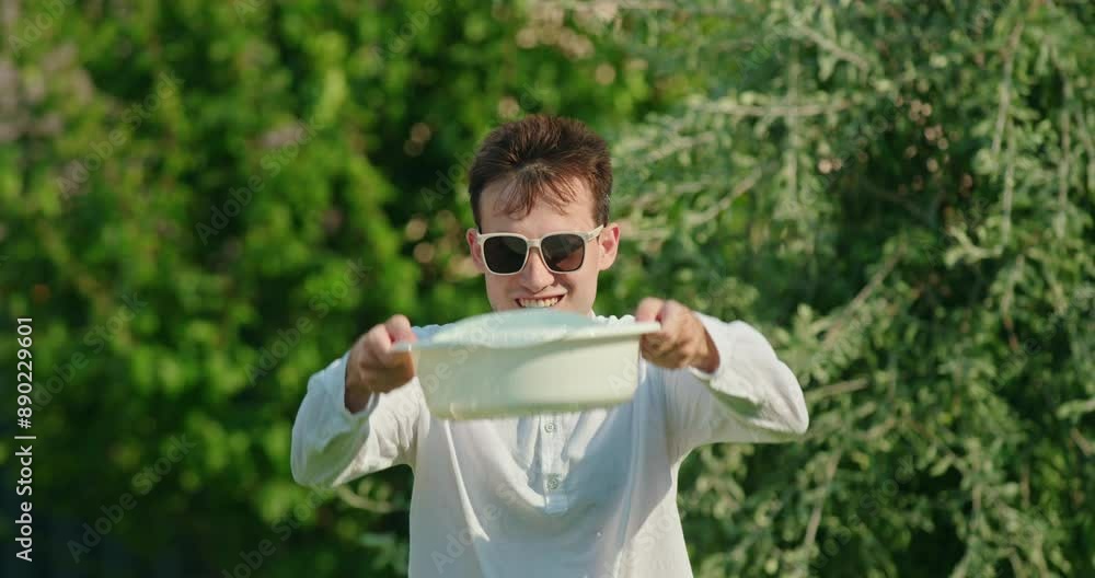 Man in a shirt and sunglasses pouring water over himself to cool down in extreme heat Man in a shirt and sunglasses pouring water over himself to cool down in extreme heat