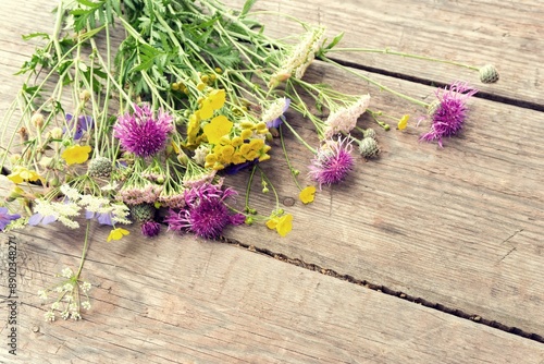 Colorful bouquet of meadow flowers on chalkboard background with empty space. Summer solstice bouquet. Top view, shallow depth of field.