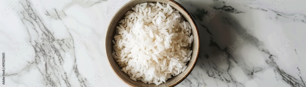 A bowl of cooked white rice set on a white and gray marble countertop. Perfect for culinary, food, and kitchen-related themes. A bowl of cooked white rice set on a white and gray marble countertop. Perfect for culinary, food, and kitchen-related themes.