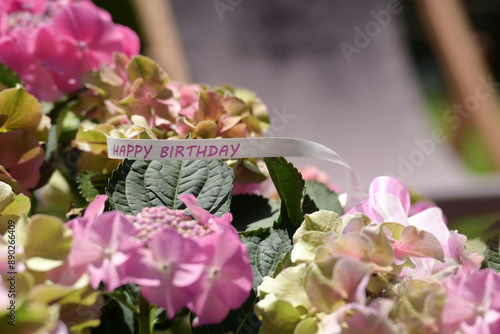 Hortensia gift with happy birthday ribbon, flowers in a garden #890266409