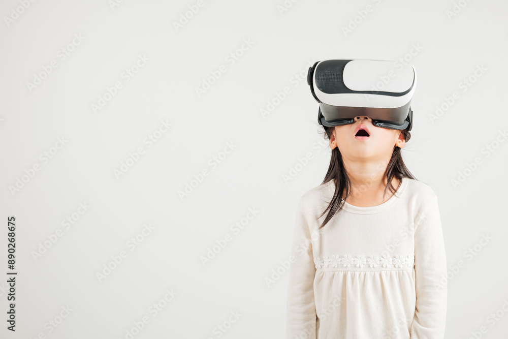 Smiling young kid girl confidence excited wear VR headset device during virtual reality experience isolated white background, Asian happy portrait kindergarten child playing video game studio shot Smiling young kid girl confidence excited wear VR headset device during virtual reality experience isolated white background, Asian happy portrait kindergarten child playing video game studio shot