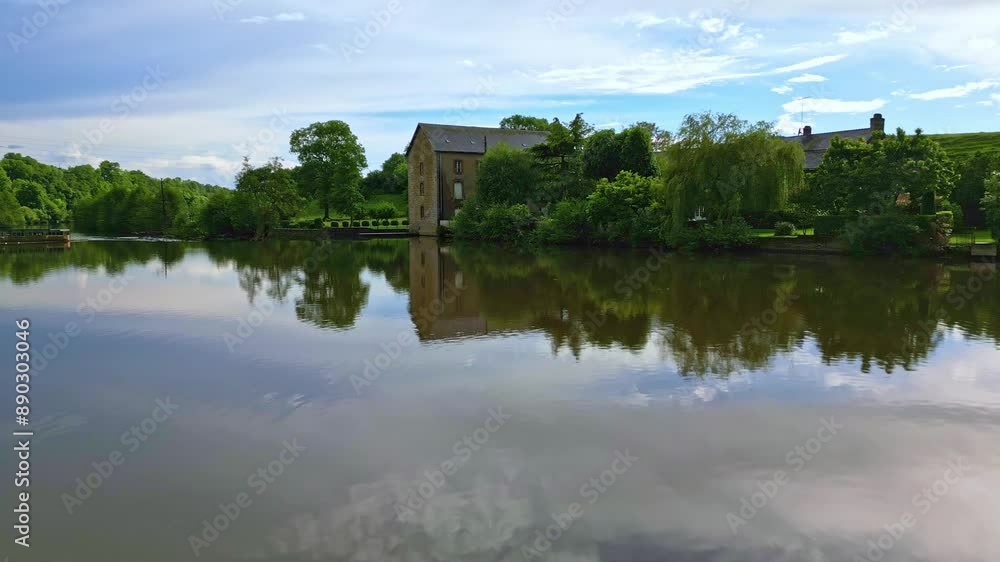 Drone flying over water surface of Mayenne River with Saint-Baudelle lock or weir, France. Aerial backward Drone flying over water surface of Mayenne River with Saint-Baudelle lock or weir, France. Aerial backward