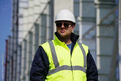 Portrait of young architect with reflective clothing on construction site and with a mask 