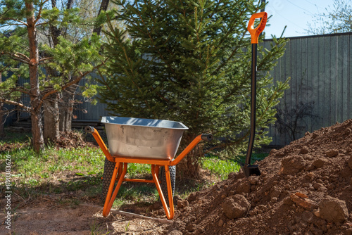 wheelbarrow for transporting soil and a shovel in the garden
