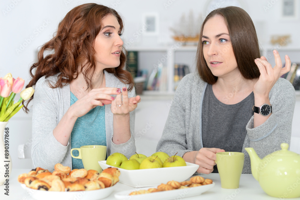 Two best friends eating while sitting at the table together Two best friends eating while sitting at the table together