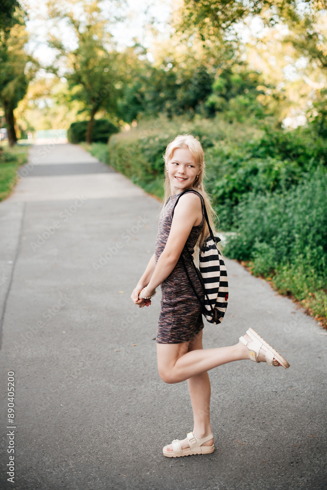 A cheerful girl poses in a stylish patterned dress on a sunny day. Her playful attitude and the bright setting give off vibes of fun and youthfulness, perfect for casual and fashion stock photos. A cheerful girl poses in a stylish patterned dress on a sunny day. Her playful attitude and the bright setting give off vibes of fun and youthfulness, perfect for casual and fashion stock photos.