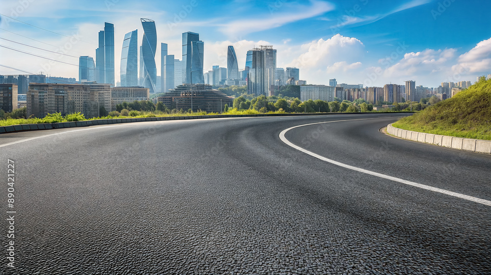 Fototapeta premium Curved asphalt road leading to a modern city skyline. Urban landscape background with copy space