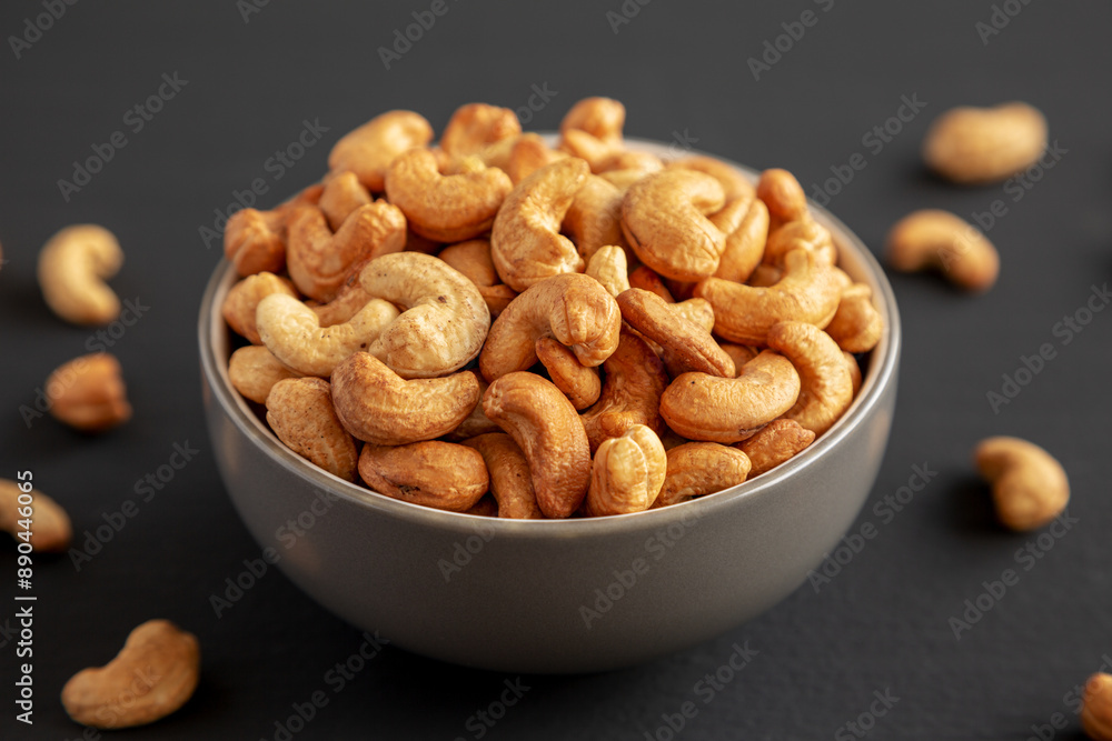 Roasted Organic Cashews in a Bowl on a black background, side view. Roasted Organic Cashews in a Bowl on a black background, side view.