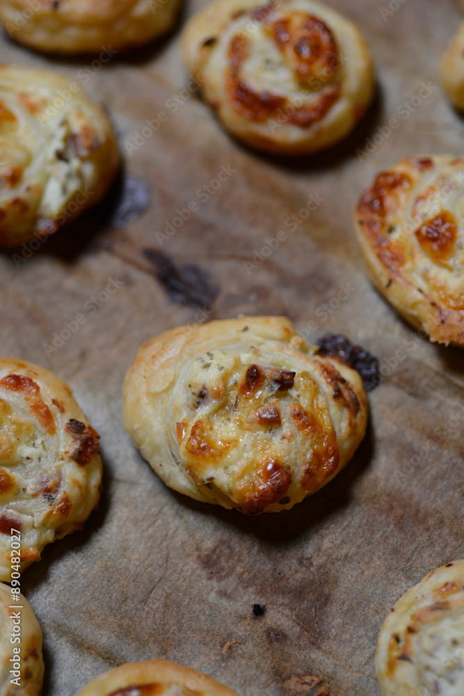Close up of a tray with puff pastry rolls with cheese and ham Close up of a tray with puff pastry rolls with cheese and ham