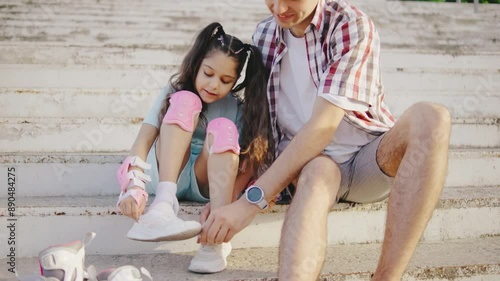 Brother and sister bond on steps with roller skates, creating joyful memories. Siblings are carefree and happy, enjoying their time together surrounded by nature and urban setting photo