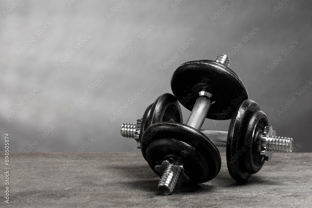 Obraz premium Two barbells on grey textured table. Space for text