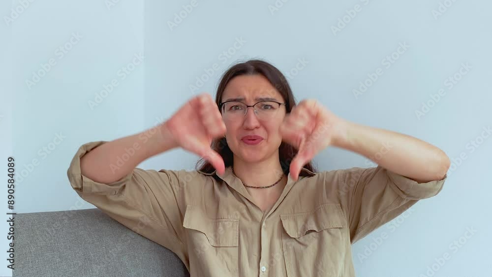 Young attractive girl shows thumbs down in disappointment Young attractive girl shows thumbs down in disappointment