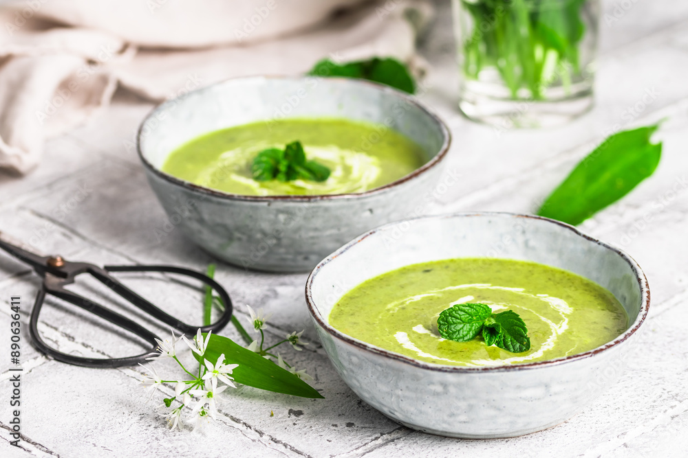 Two bowls of wild garlic soup on light gray background Two bowls of wild garlic soup on light gray background