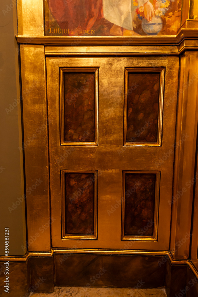 imagen detalle pared con una puerta de madera dorada, con pequeños rectángulos de madera oscura dentro imagen detalle pared con una puerta de madera dorada, con pequeños rectángulos de madera oscura dentro