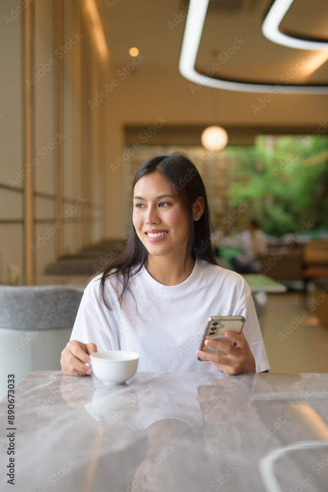Young Thai Woman Using Phone at Coffee Shop Young Thai Woman Using Phone at Coffee Shop