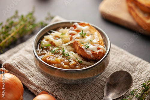 Classic French onion soup baked with cheese croutons sprinkled with fresh thyme. photo