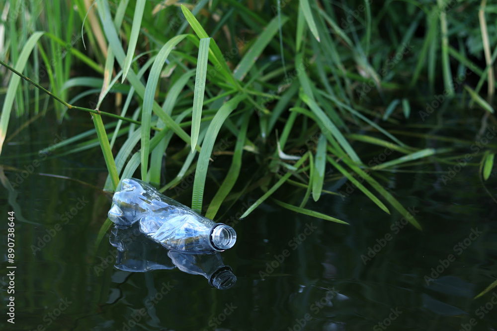 Plastic bottle in water, lake or river. Plastic pollution. Pollution of reservoirs and rivers. Garbage in the river close-up. An abandoned bottle floats on the lake. Food plastic in river water Plastic bottle in water, lake or river. Plastic pollution. Pollution of reservoirs and rivers. Garbage in the river close-up. An abandoned bottle floats on the lake. Food plastic in river water